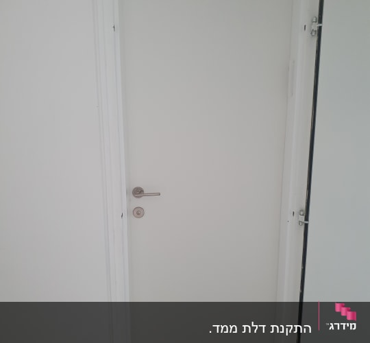דלת לבנה עם ידית מתכת כסופה